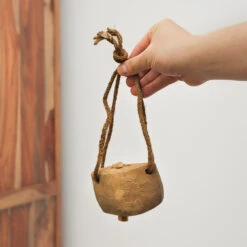 Wooden Cowbell -CARVED CULTURE Sale Wooden Cowbell with Jute String Held in Hand for Scale